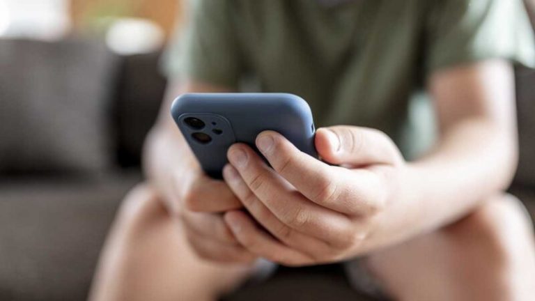 teenager boy is using smartphone at home - home schooling
