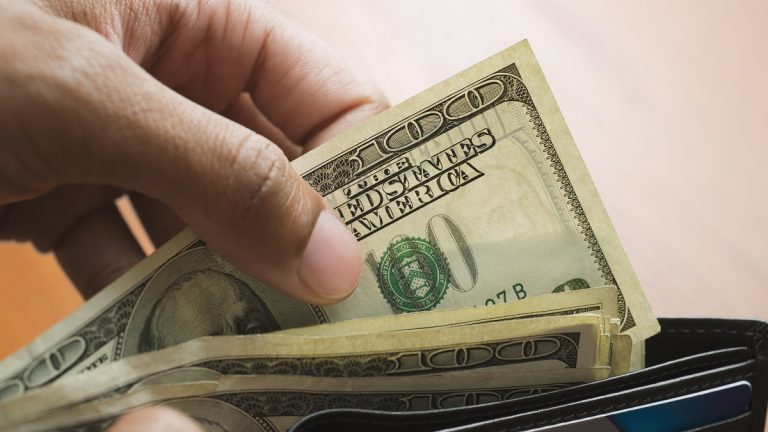 Mixed Race man taking money out of wallet
